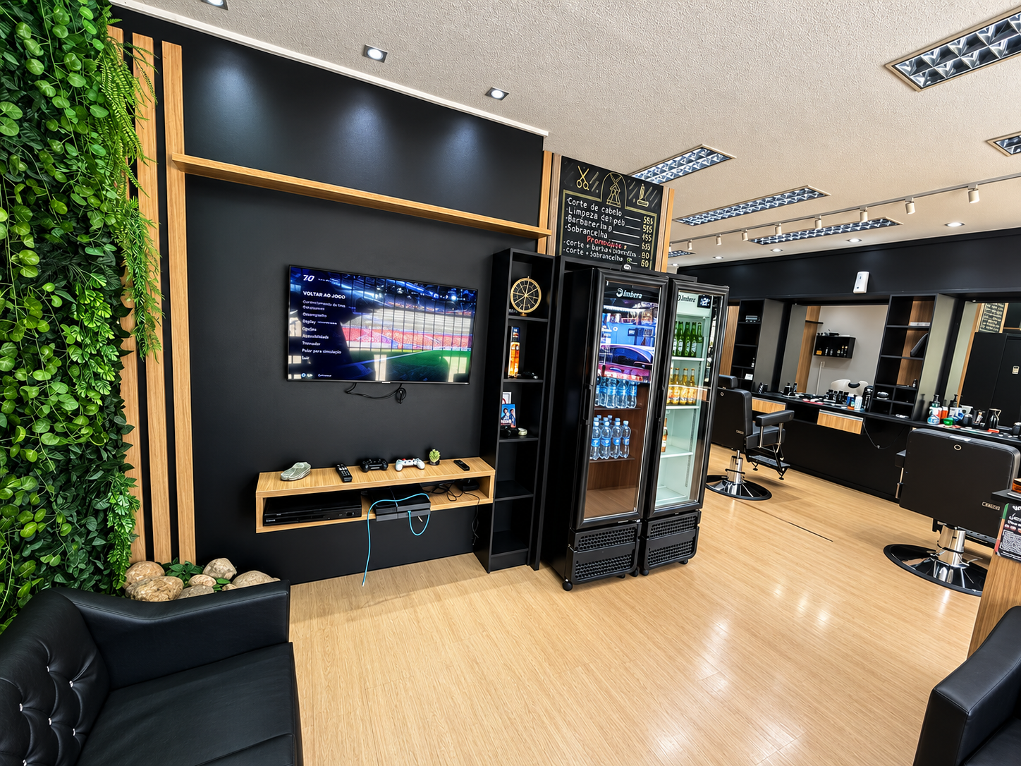 Área de espera da Barbearia Joinville com TV, videogame e geladeira de bebidas